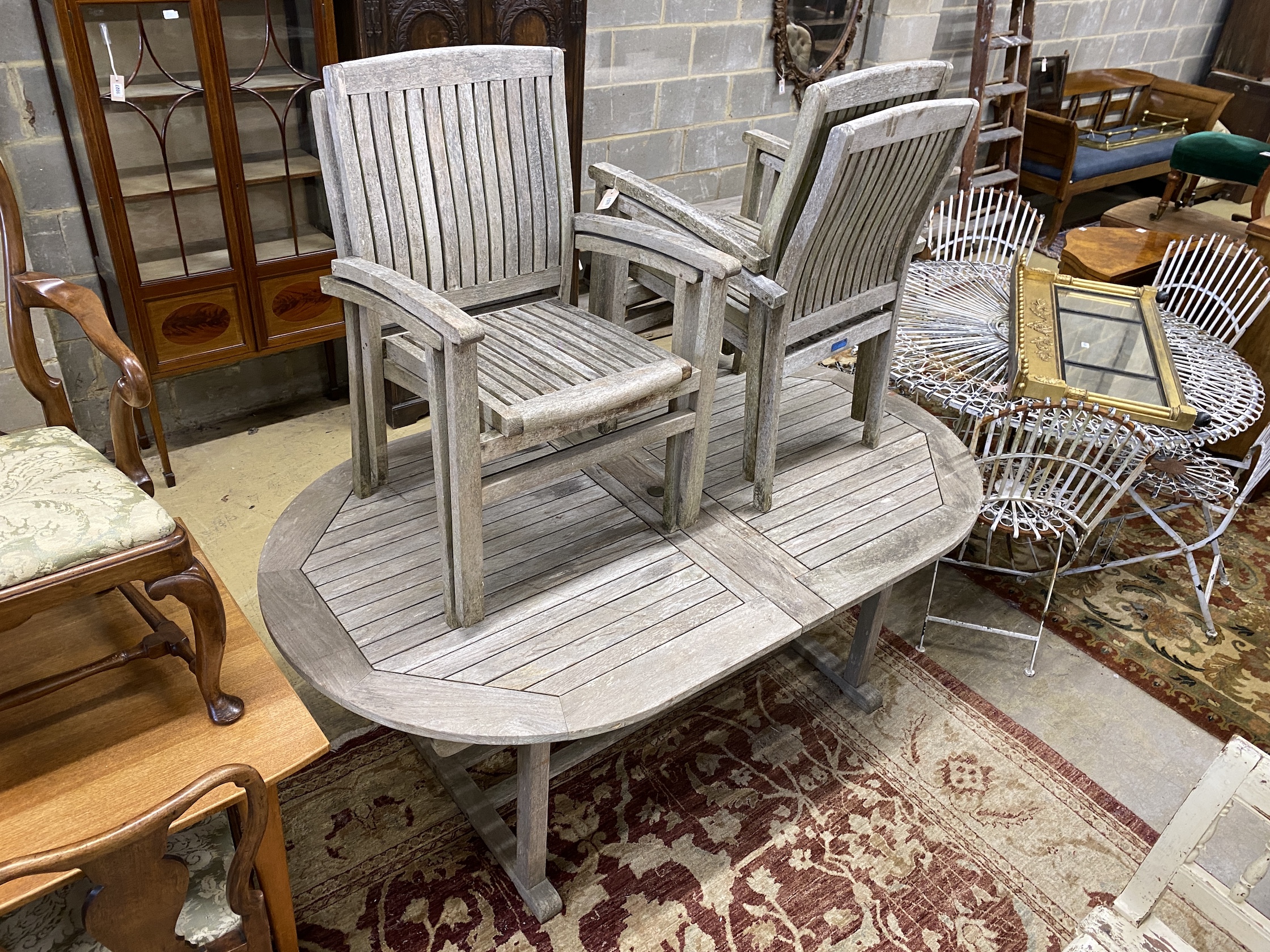 A Lindsey weathered teak garden table, length 190cm, width 110cm, height 74cm and four stacking elbow chairs